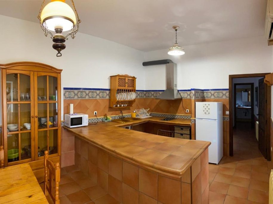 Cocina amplia con muebles de madera, barra central y electrodomésticos modernos.